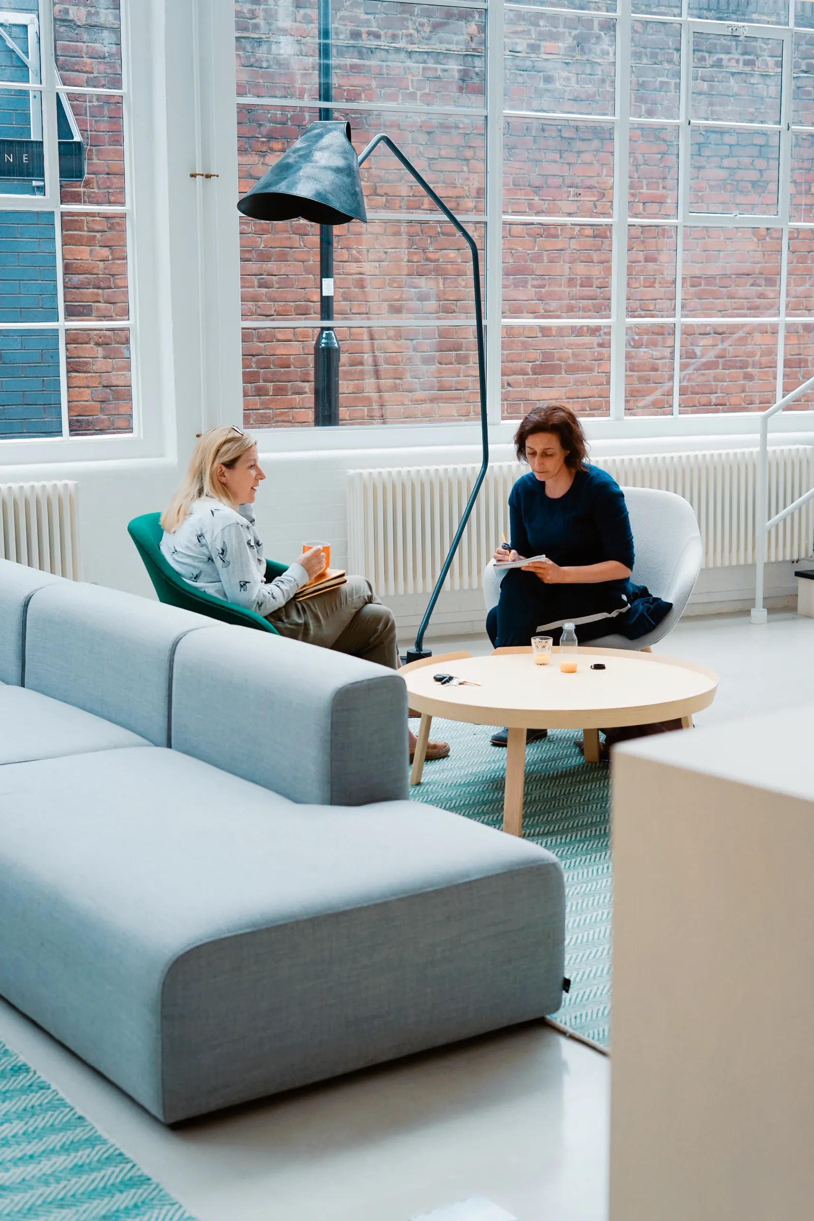 Två personer i lugnt samtal i ett ljust rum – stöd vid kris, rehabilitering och återgång i arbete